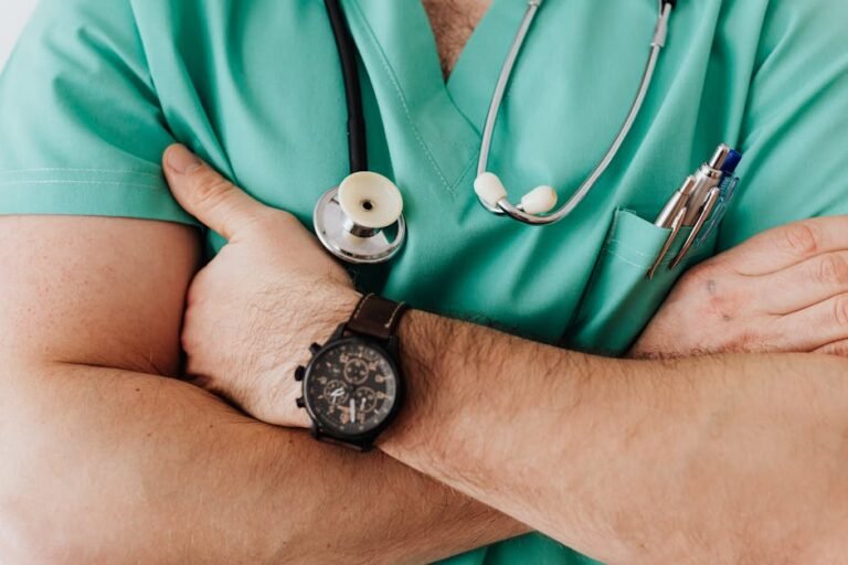 Close-up of a healthcare professional with arms crossed wearing medical scrubs and stethoscope. Arbor Associates Data Breach